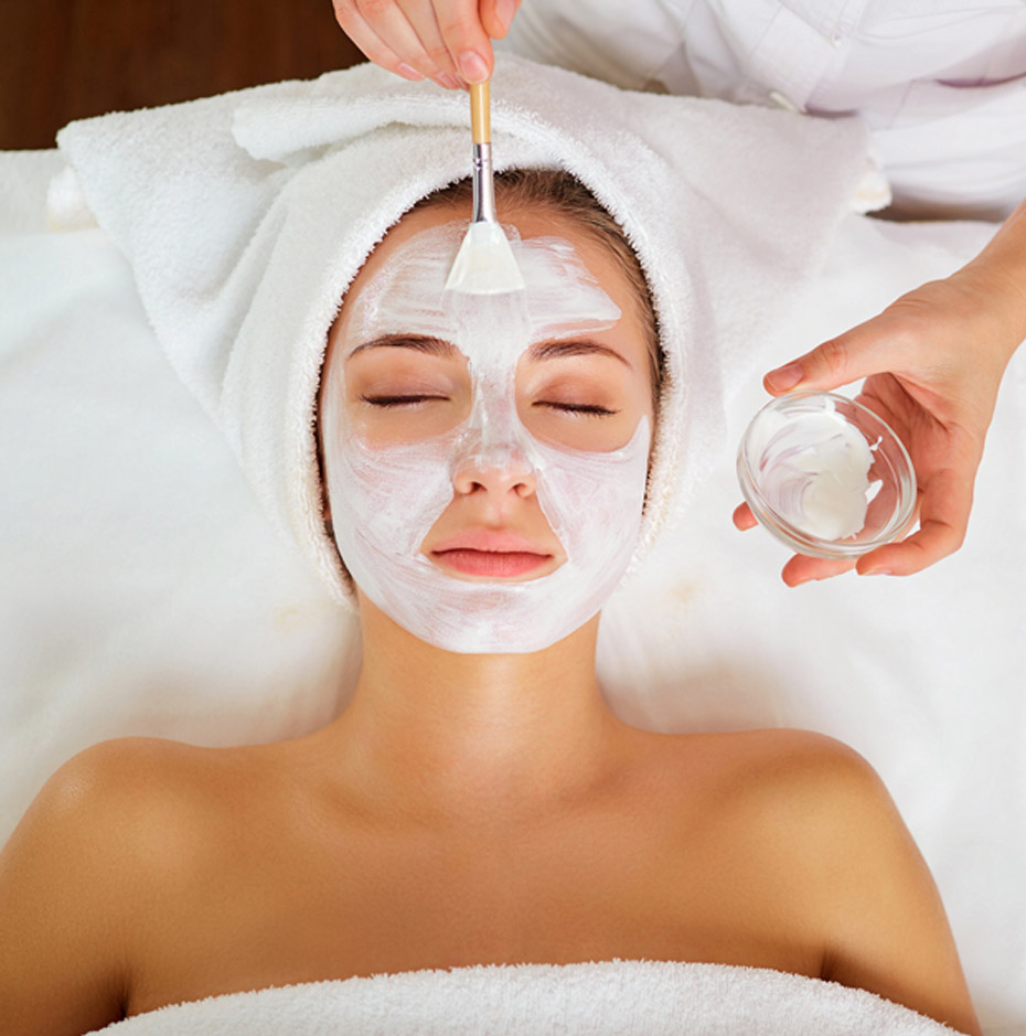 esthetician-applying-a-mask-to-womans-face-during-deep-cleansing-facial