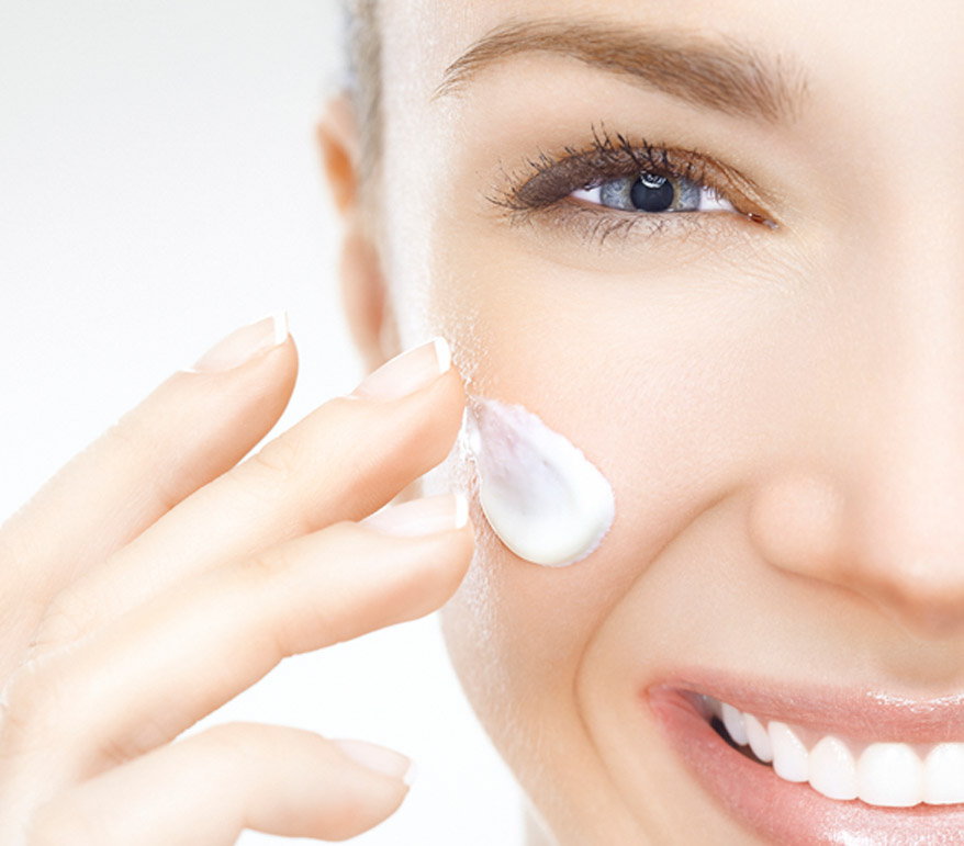 woman-applying-cream-to-her-face-after-receiving-hydrating-anti-aging-facial