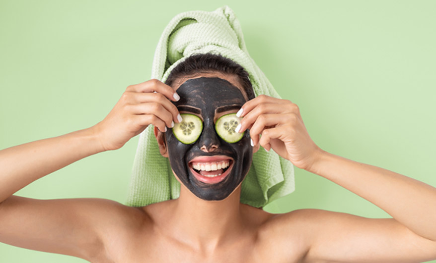 woman-holding-cucumber-slices-over-her-eyes-during-deep-cleansing-facial
